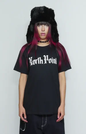 Camiseta North Point, de corte amplio y silueta cuadrada, con hombros caídos y mangas anchas. En el frontal presenta tipografía gótica de alto contraste en tono claro, con letras estilizadas, afiladas y ornamentales, inspiradas en la estética dark y urbana. Diseño centrado en la gráfica, manteniendo una base minimalista que resalta la tipografía como elemento principal. Estilo streetwear de influencia noventera y hip hop, con una presencia visual contundente y actitud rebelde.
